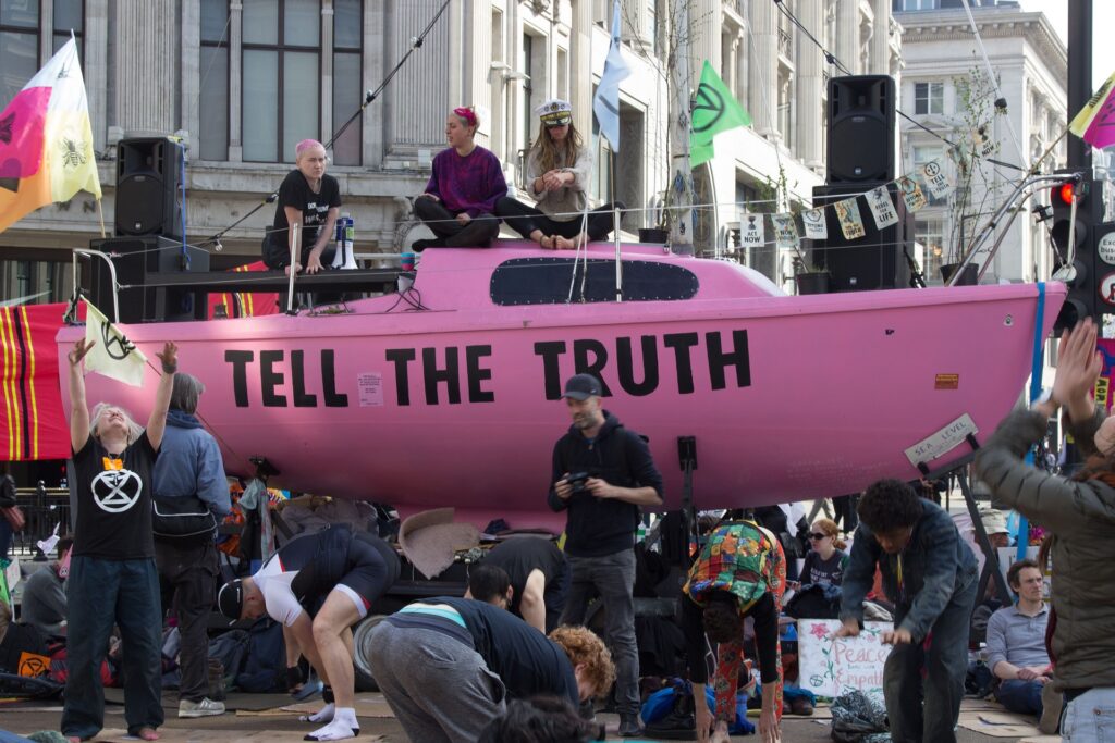 extinction rebellion activists protest with a pink boat in the city