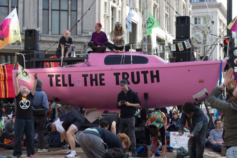 extinction rebellion activists protest with a pink boat in the city